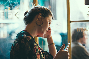 Lady listening to cell phone with wired headphones