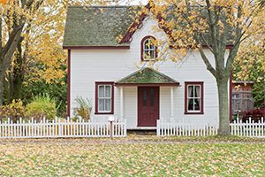 House and gated yard with fall leaves