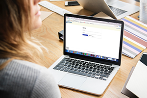 Lady sitting in front of a computer with Allentown FCU's Online Banking on screen