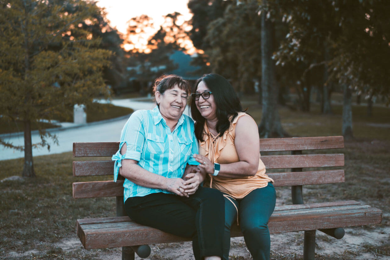 mother and daughter smiling on a bench