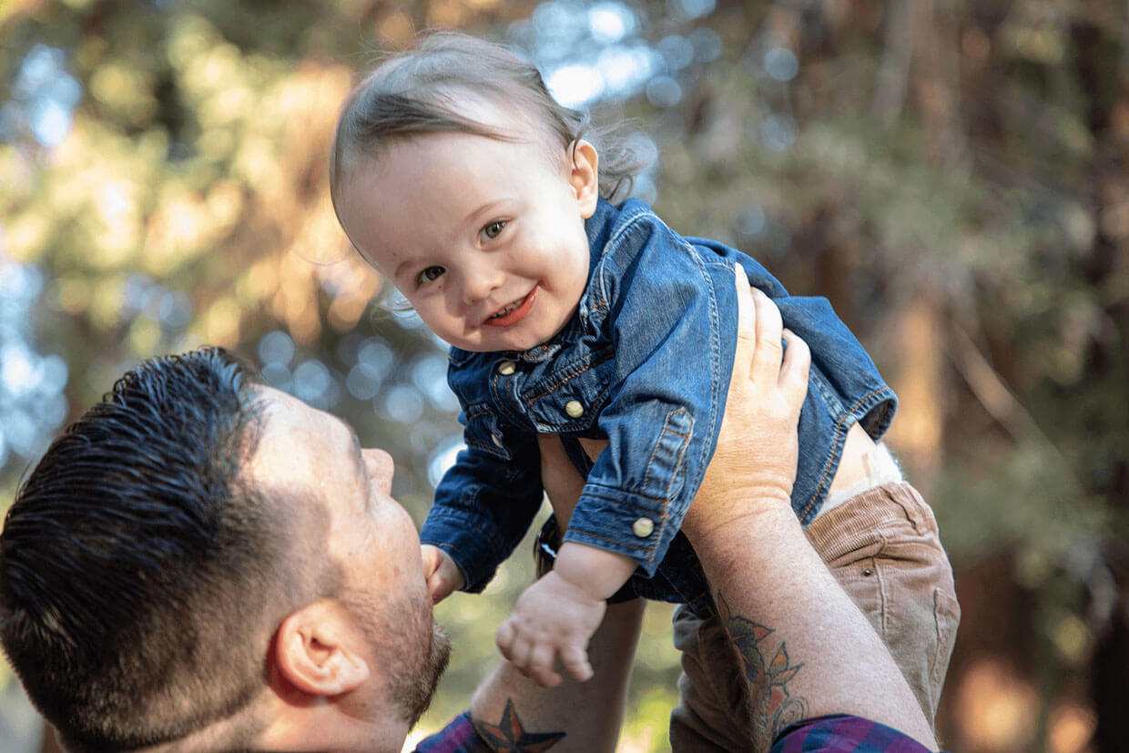 father holding up son