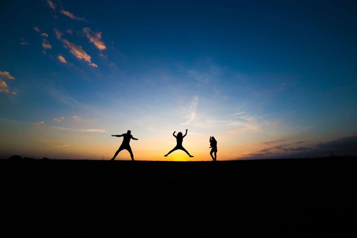 people jumping in air at sunset